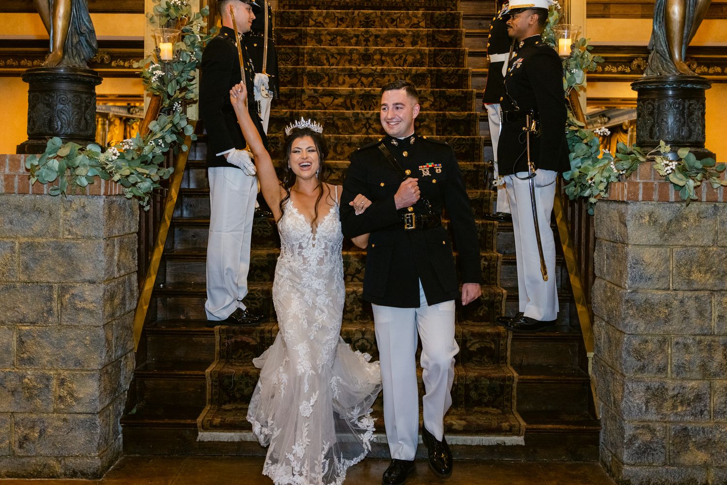 Wedding party poses on rustic stone steps with bridesmaids in white dresses and groomsmen in dark suits.