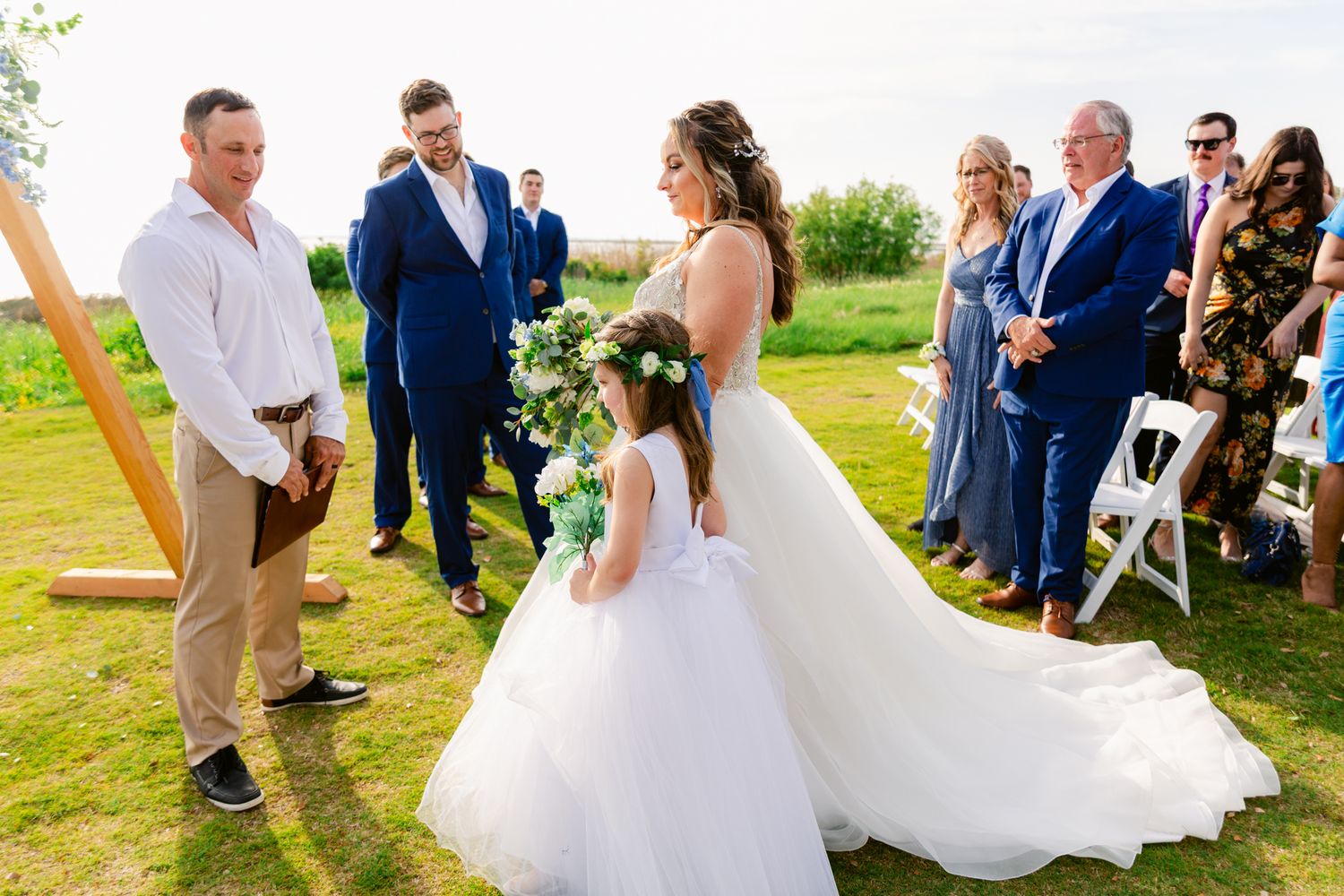 A series of wedding photos showing outdoor ceremony moments with guests and a bride in a flowing white dress.
