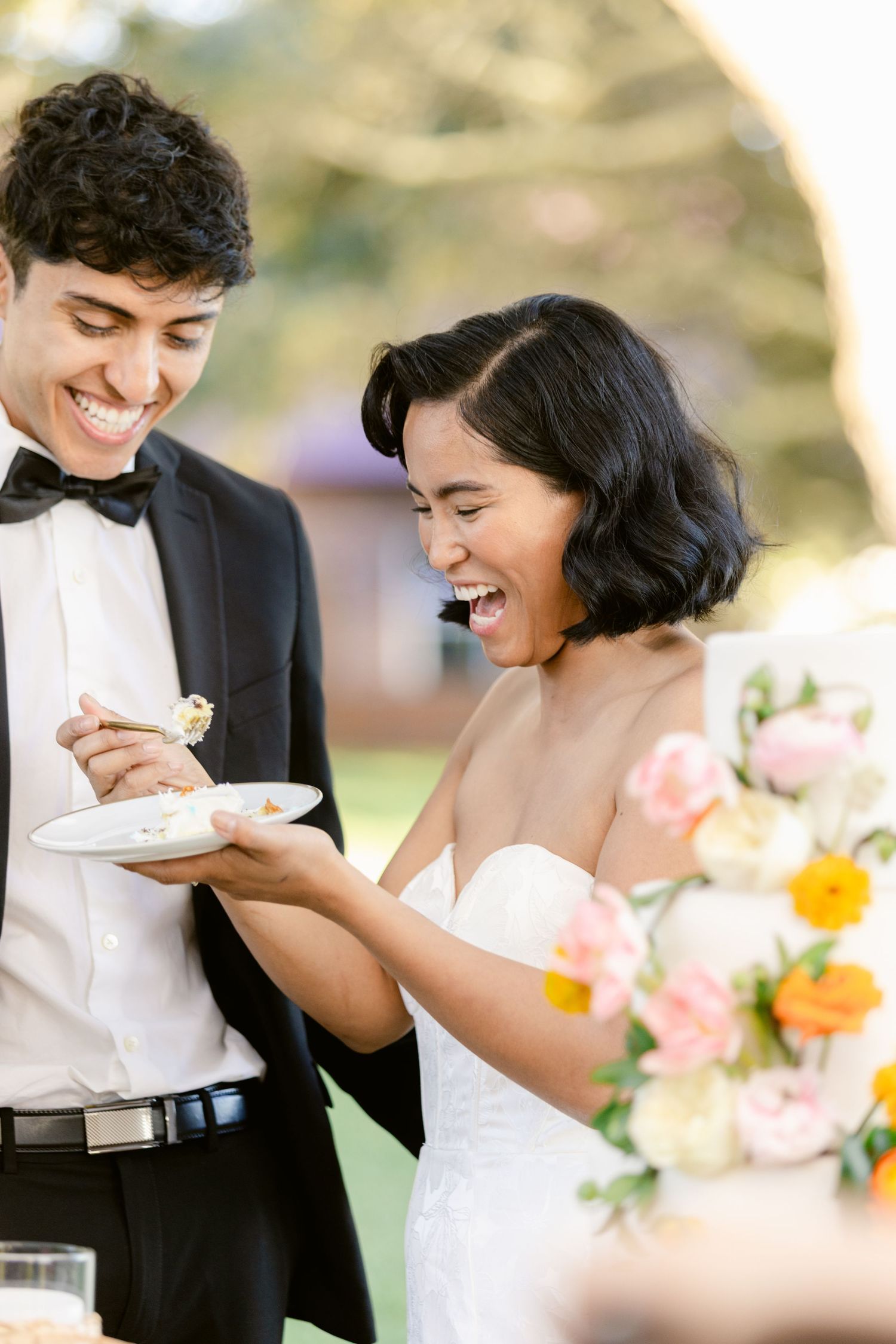 A couple shares an intimate moment while eating cake together at their wedding celebration.