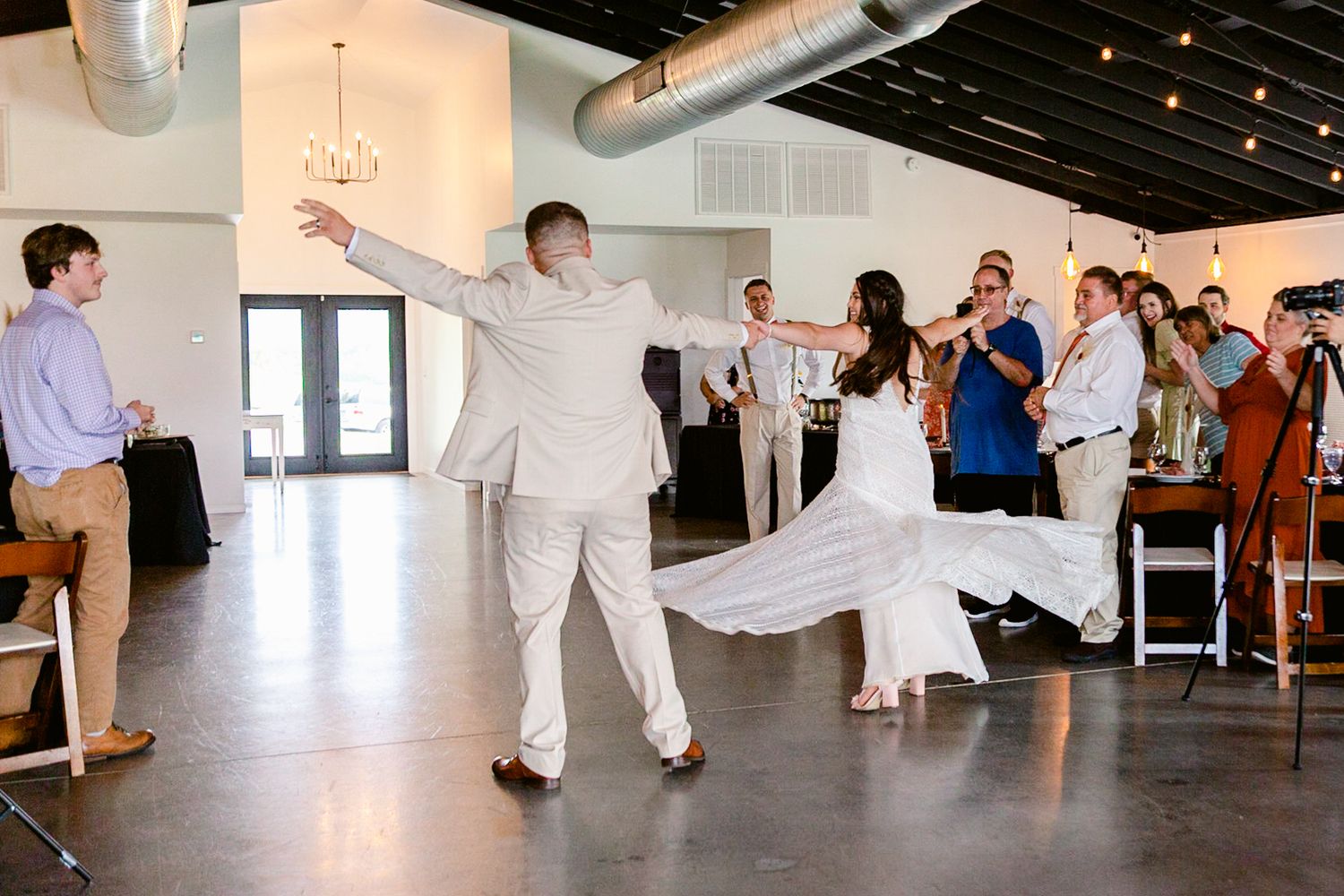 A group of dancers perform traditional Greek folk dances in a circle at a wedding reception.