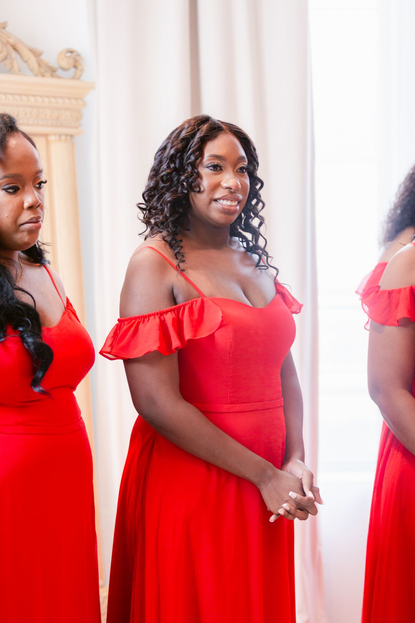 Woman in vibrant red off-shoulder dress poses elegantly in multiple angles against a light backdrop.