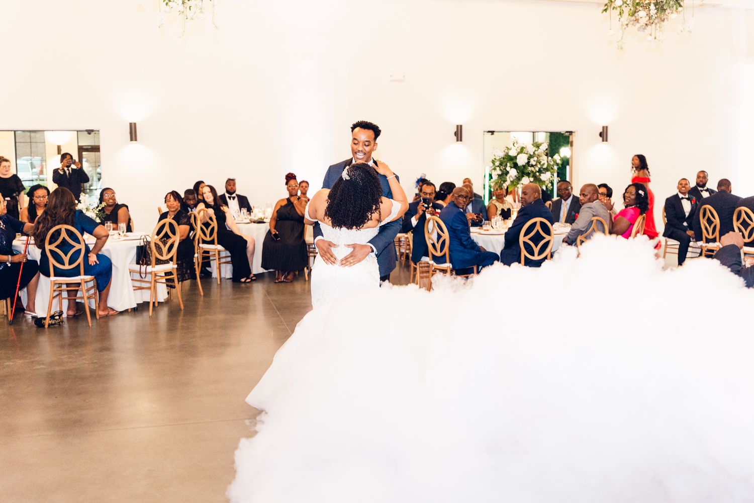 Wedding reception venue with white walls and decorative greenery.