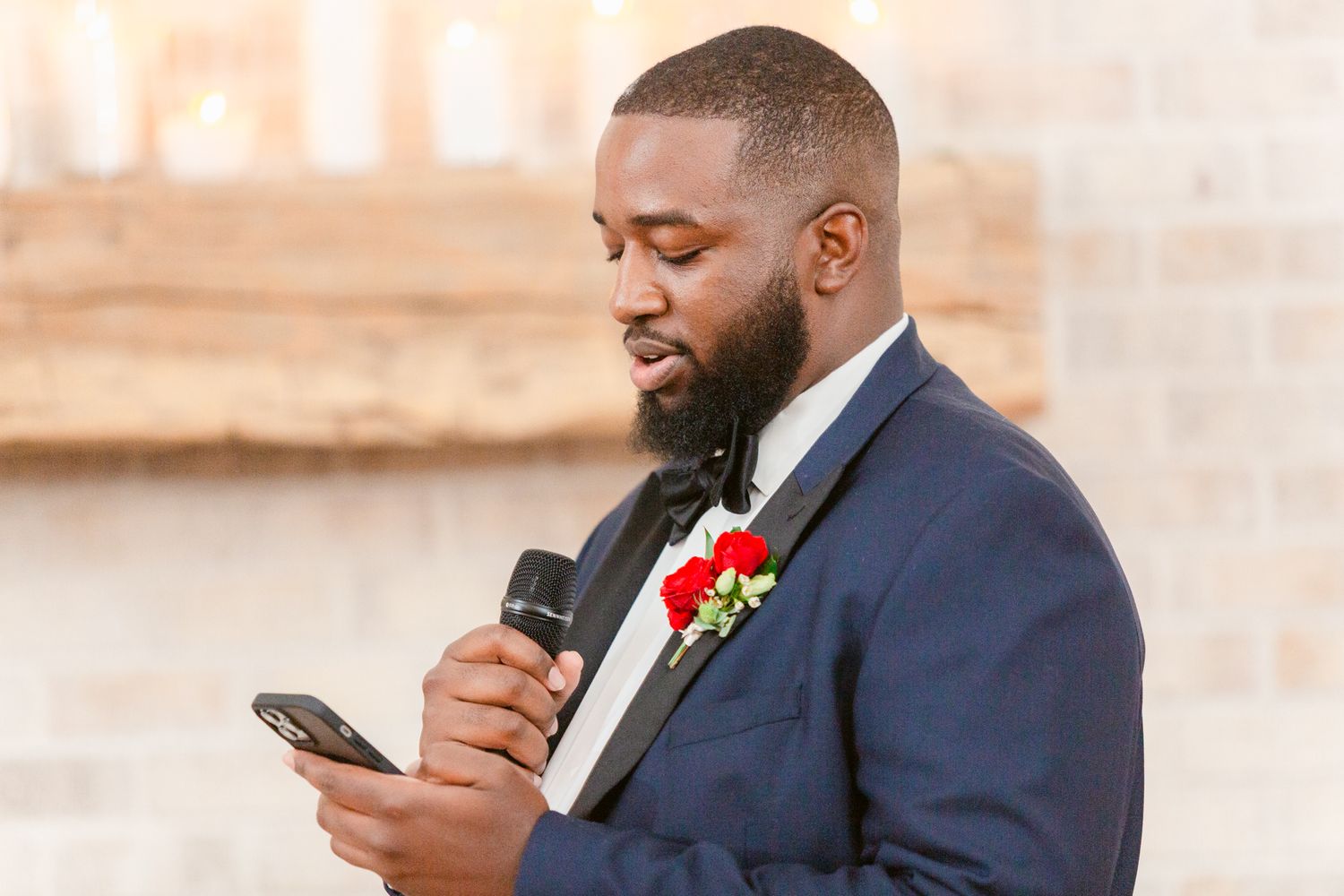 Groomsmen in navy suits checking their phones during wedding preparations.