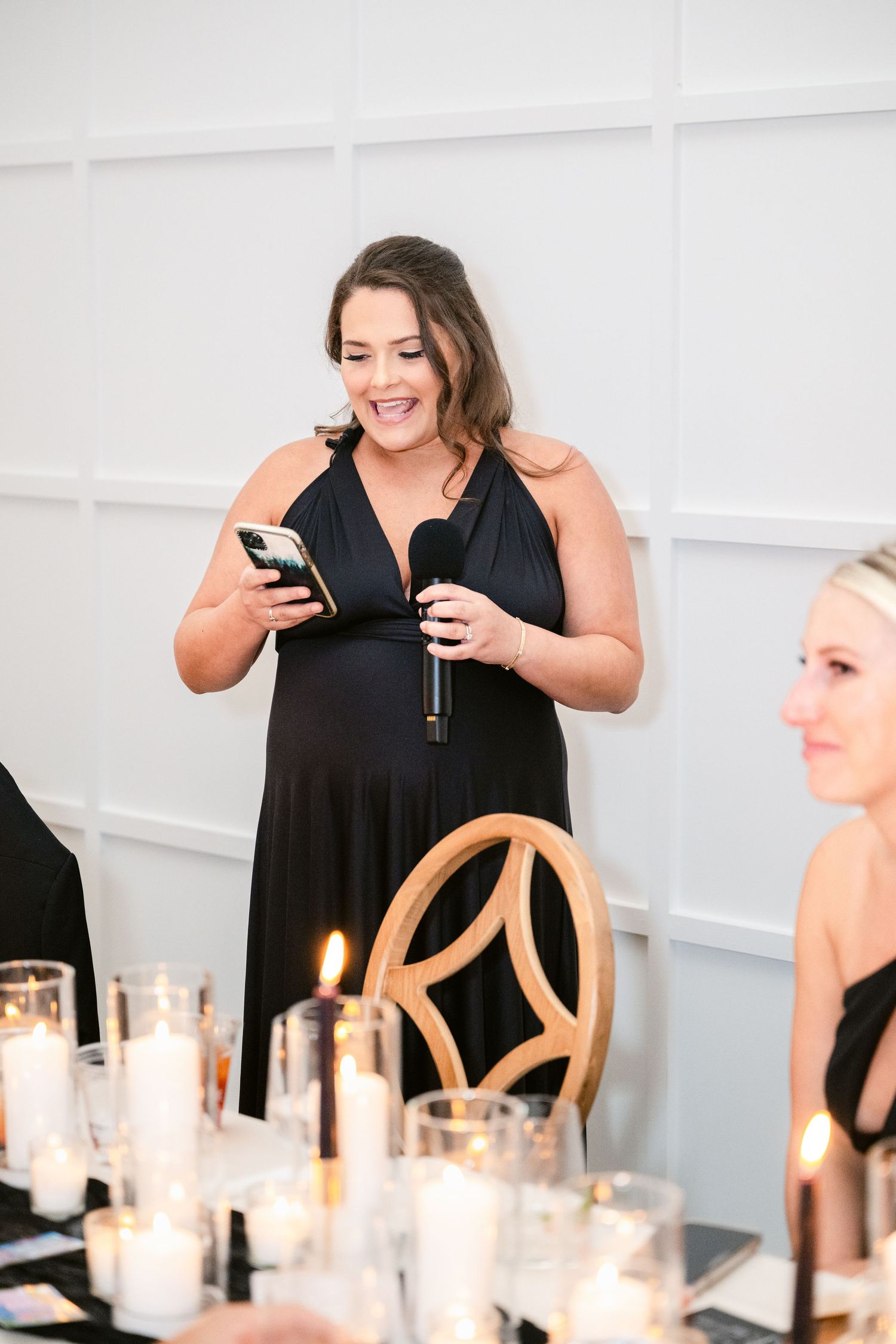 A table setting with glowing candles and elegant white decor at an upscale event.