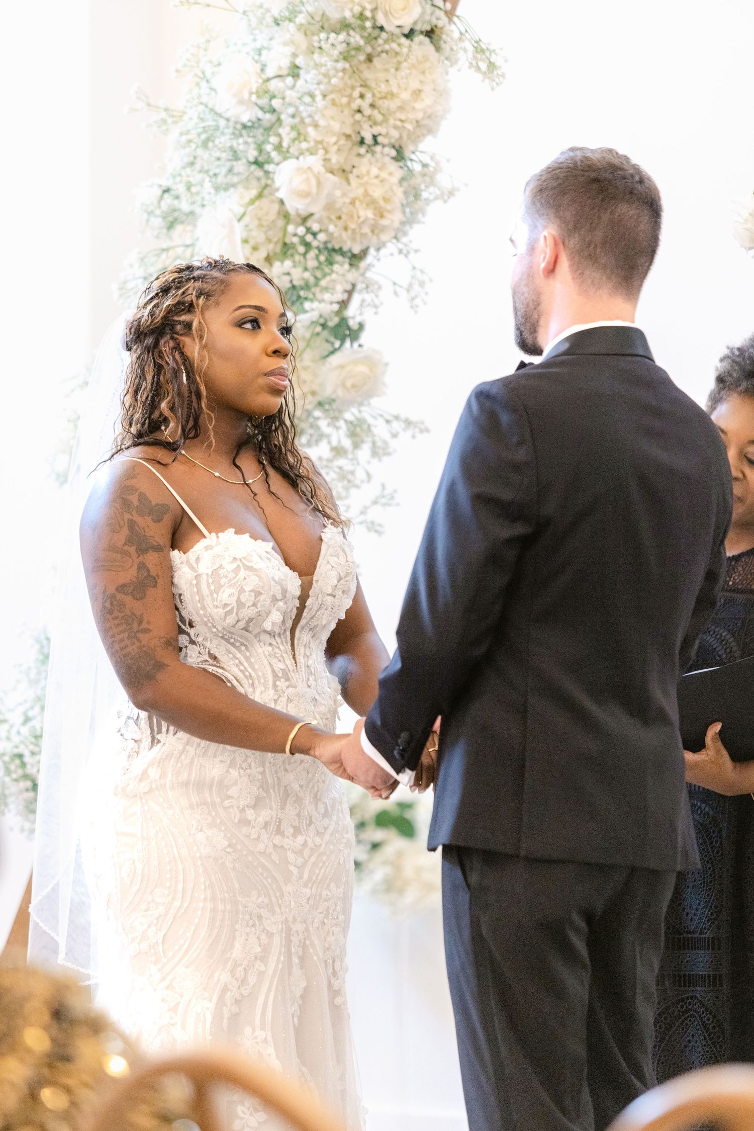 A couple exchanges vows during an intimate wedding ceremony under natural light indoors.
