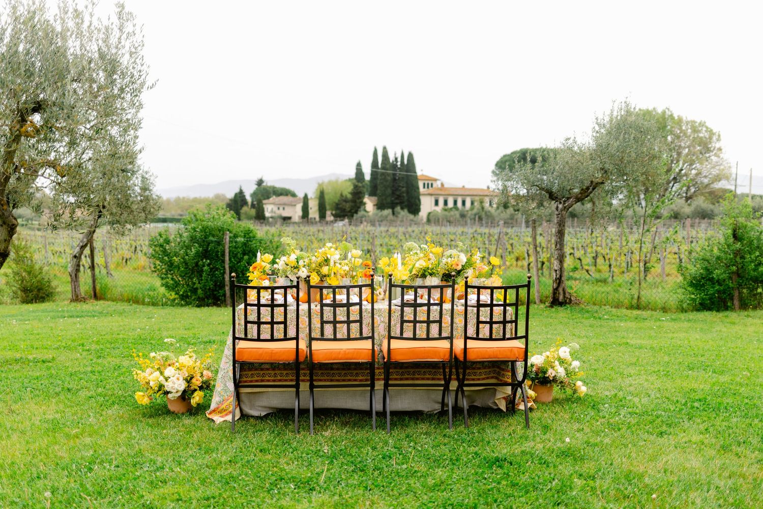 A series of outdoor wedding ceremony images showing rustic wooden benches and floral arrangements in a green field setting.