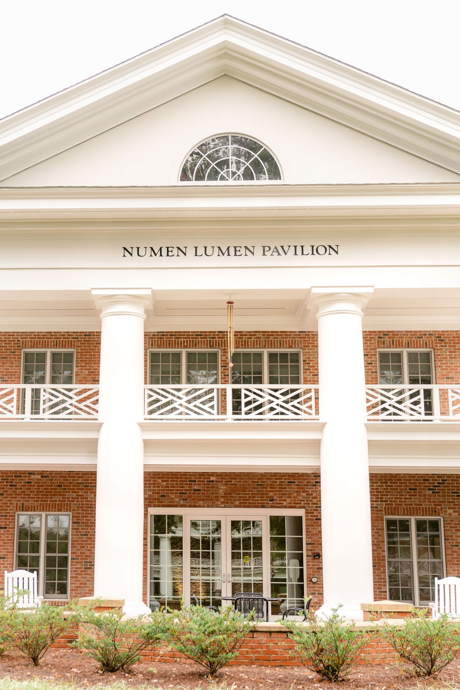 The Numen Lumen Pavilion features classic colonial architecture with white columns and a brick facade.