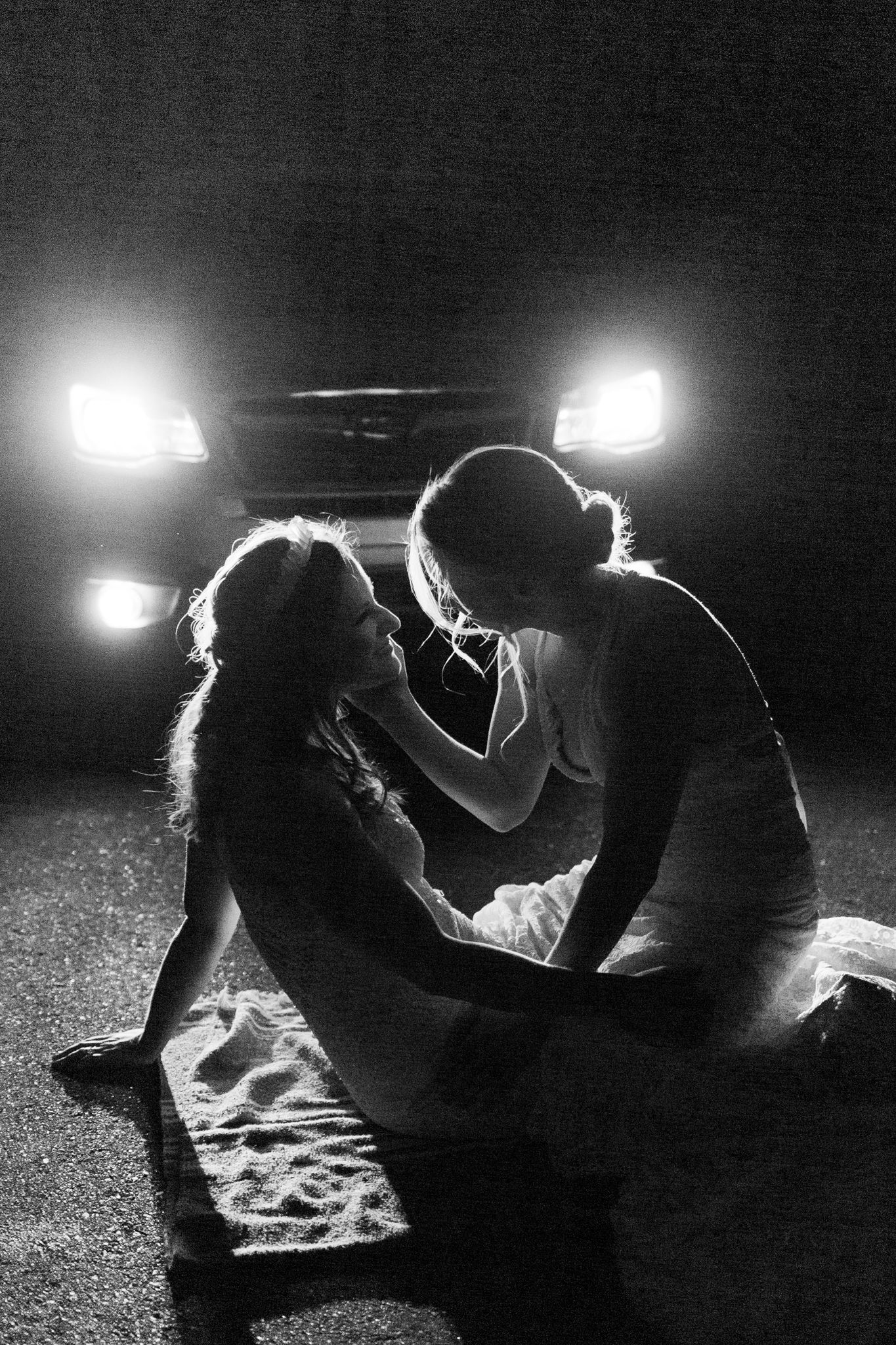 Artistic black and white silhouettes of a couple sharing an intimate moment under dramatic lighting.