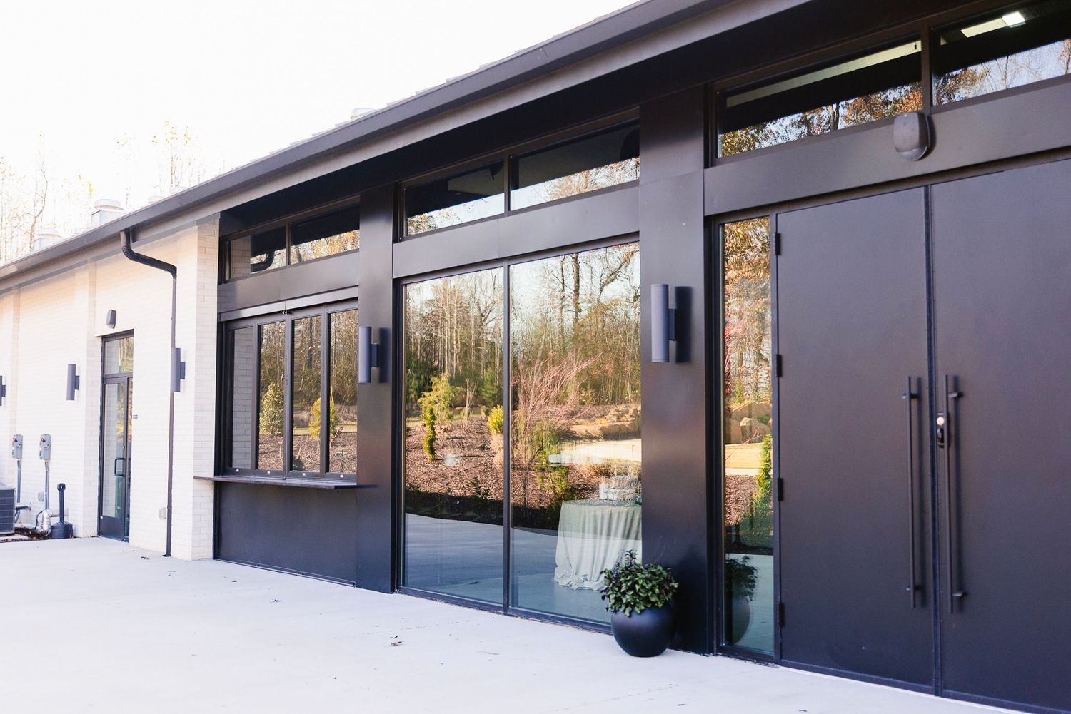 Modern commercial building exterior with glass windows and black trim features sleek architectural design.