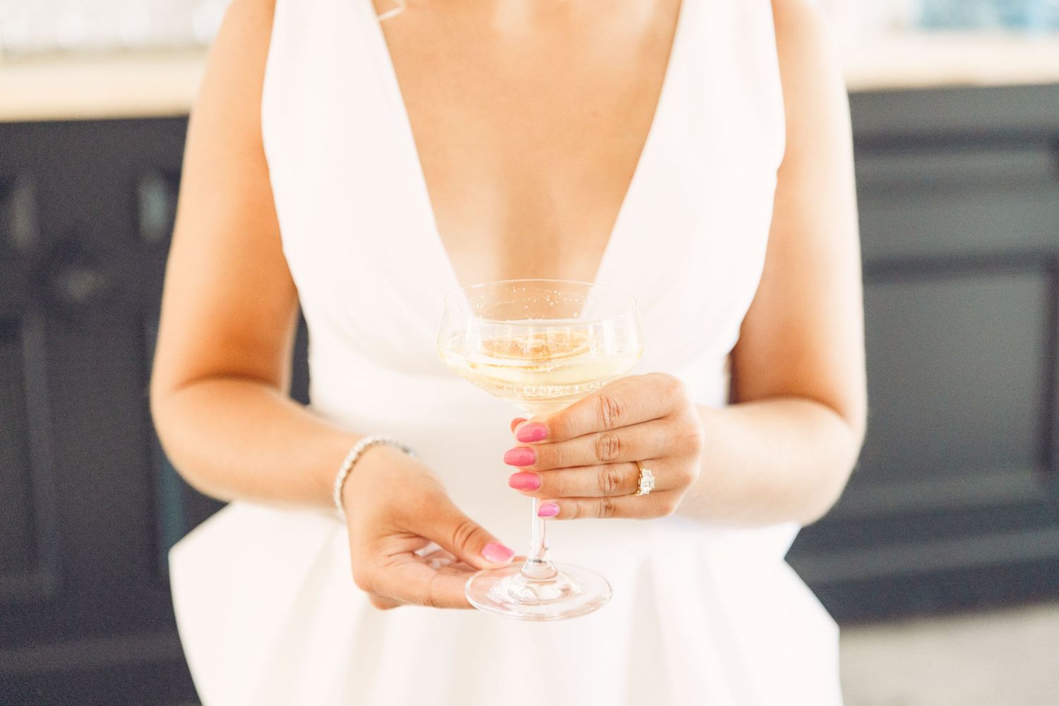 A champagne glass held delicately against a white background in an elegant setting.