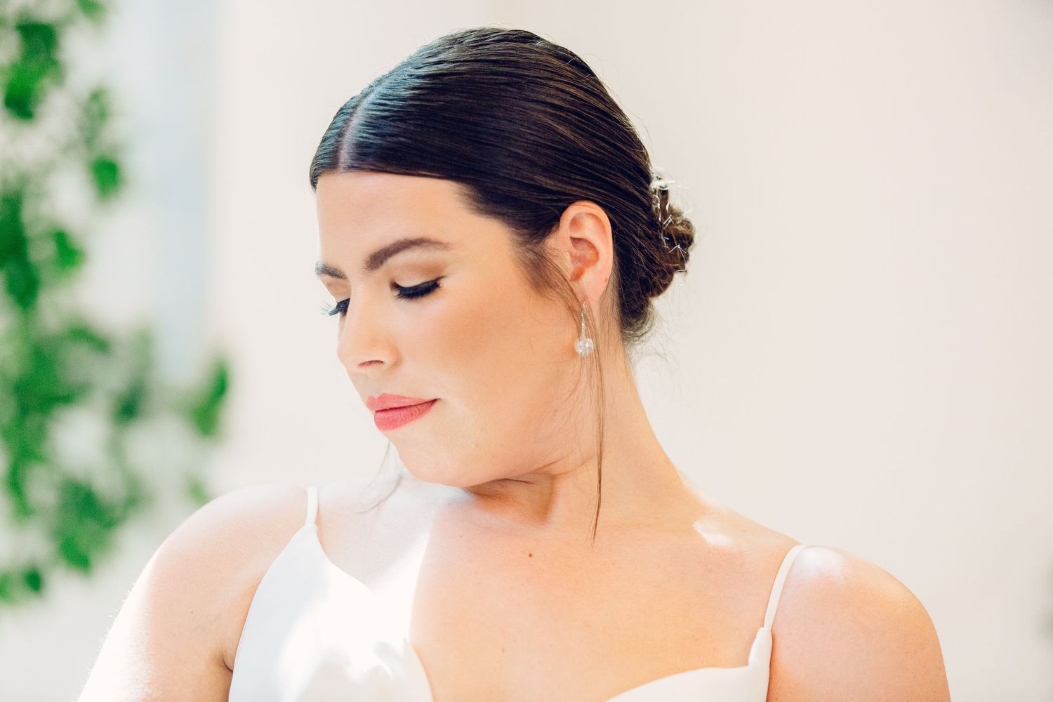 Elegant bridal portrait in a light-filled room with floral decorations.