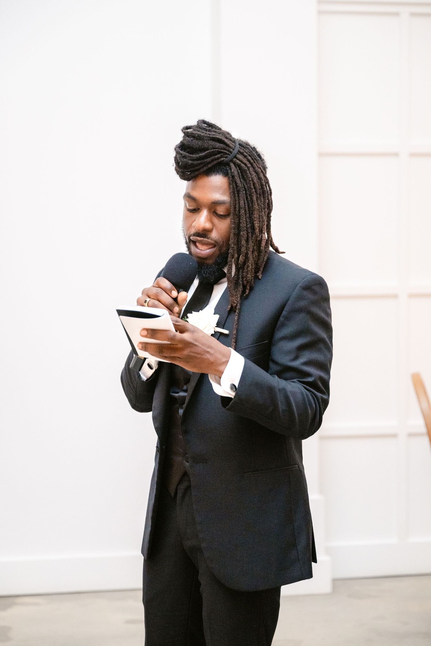 Man in black suit enjoying appetizers at an elegant event.