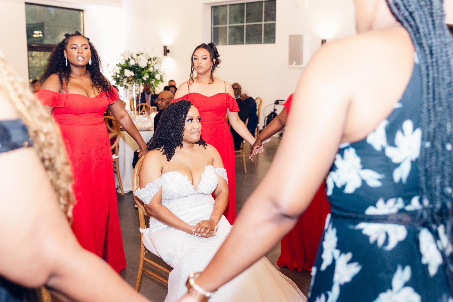 Wedding reception dance party with guests in formal attire and red dresses enjoying the celebration.