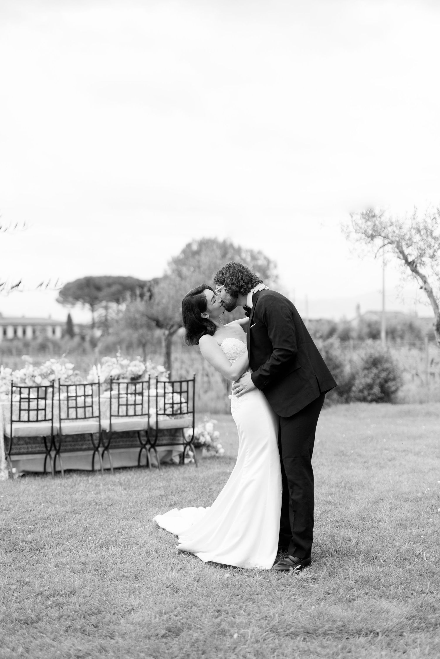 Black and white romantic wedding photos taken outdoors with garden benches in the background.