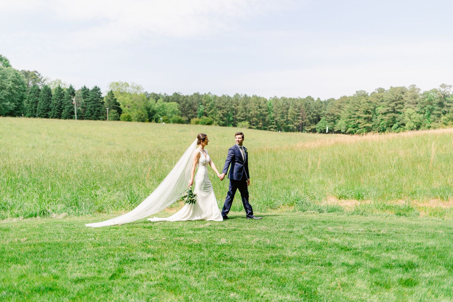A series of romantic wedding photos showing a couple walking together through rolling green meadows.