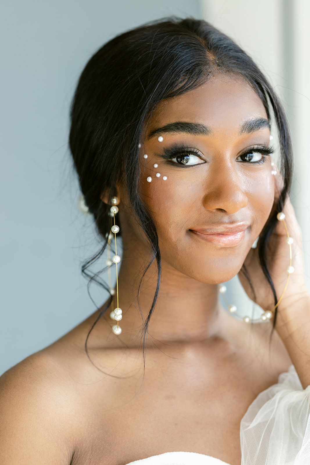 Close-up beauty portrait with delicate white pearl accents and elegant makeup details.