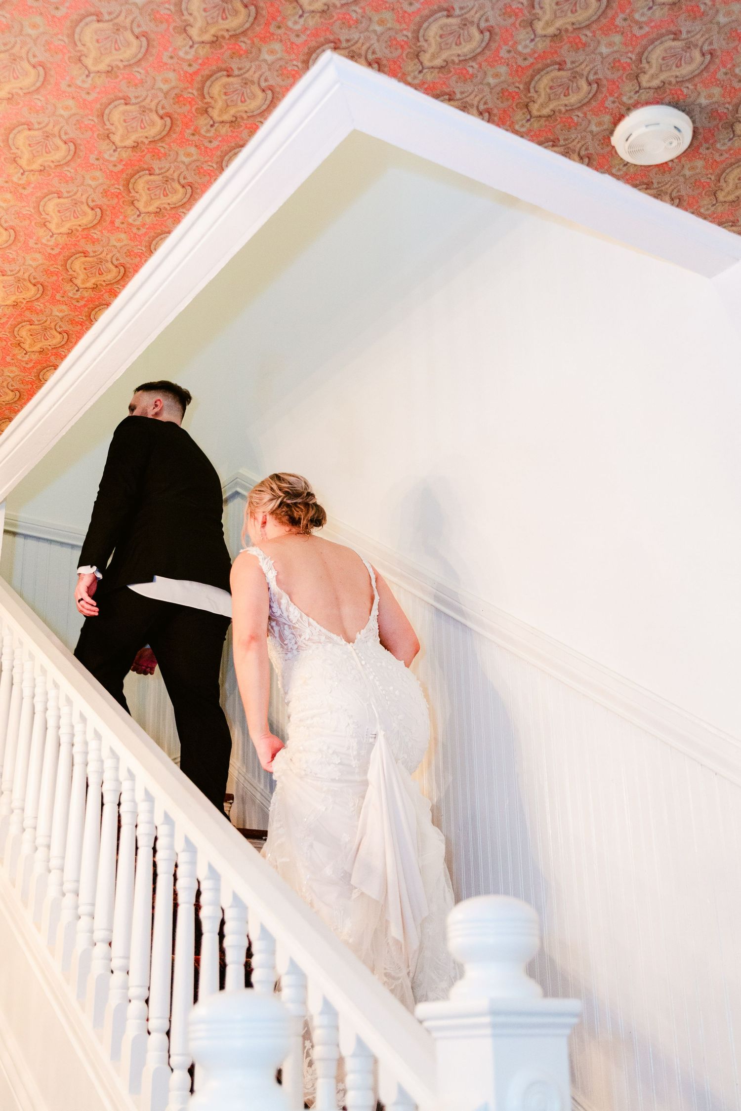 A series of photos showing someone ascending white stairs in a flowing white dress.