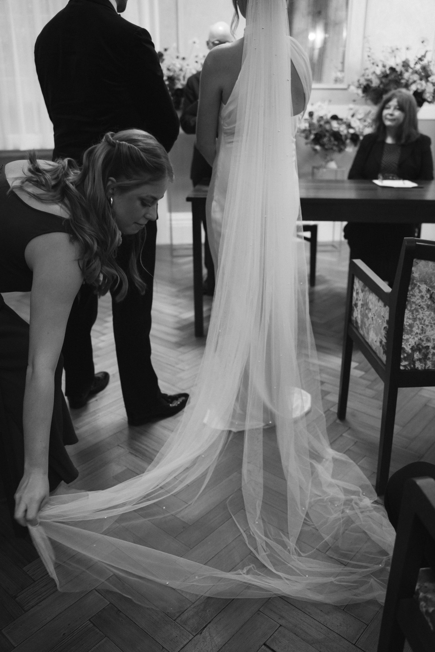 Sister of the bride adjusting her veil at the alter