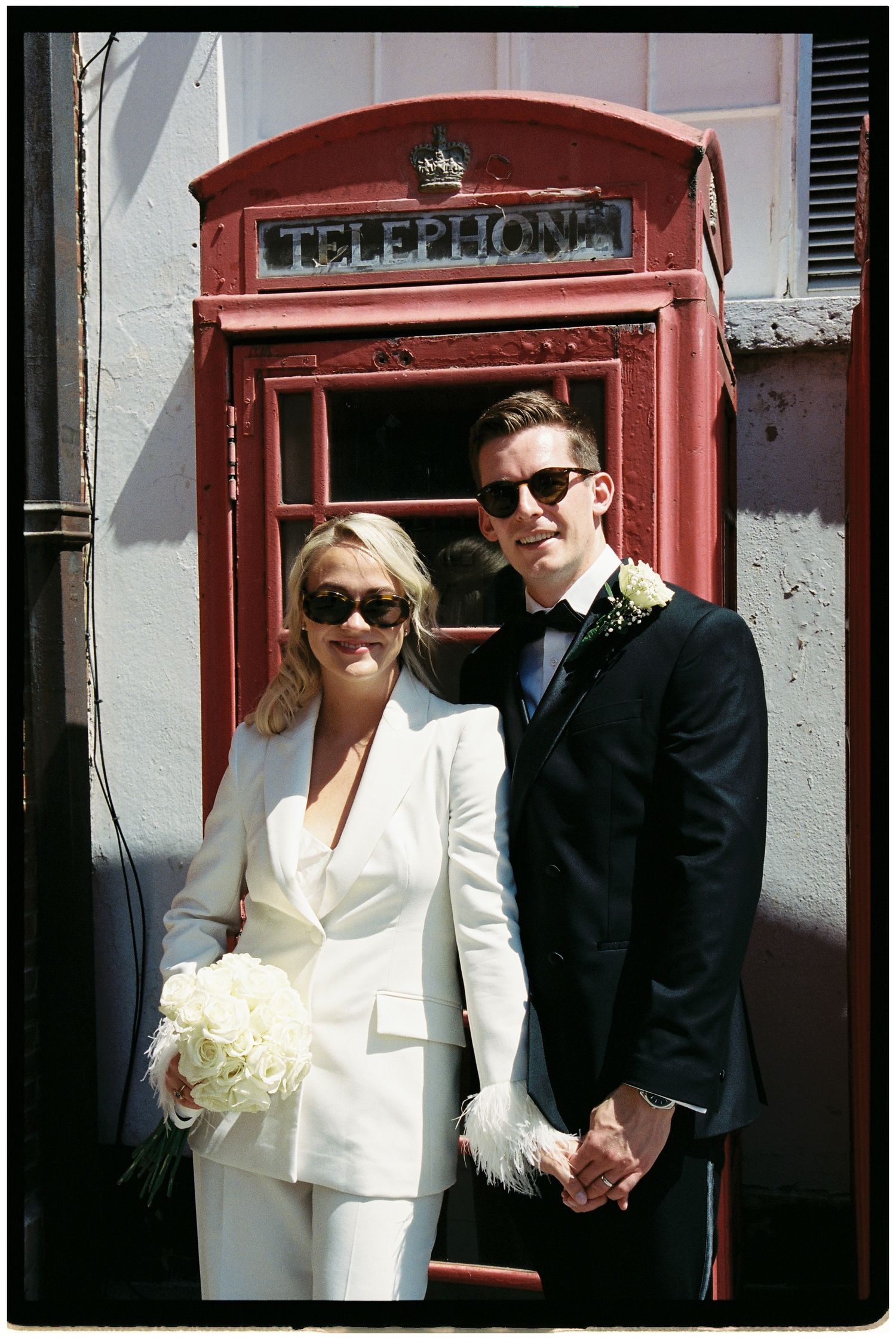 Editorial wedding portrait in front of a red telephone box in Guildford, Surrey.