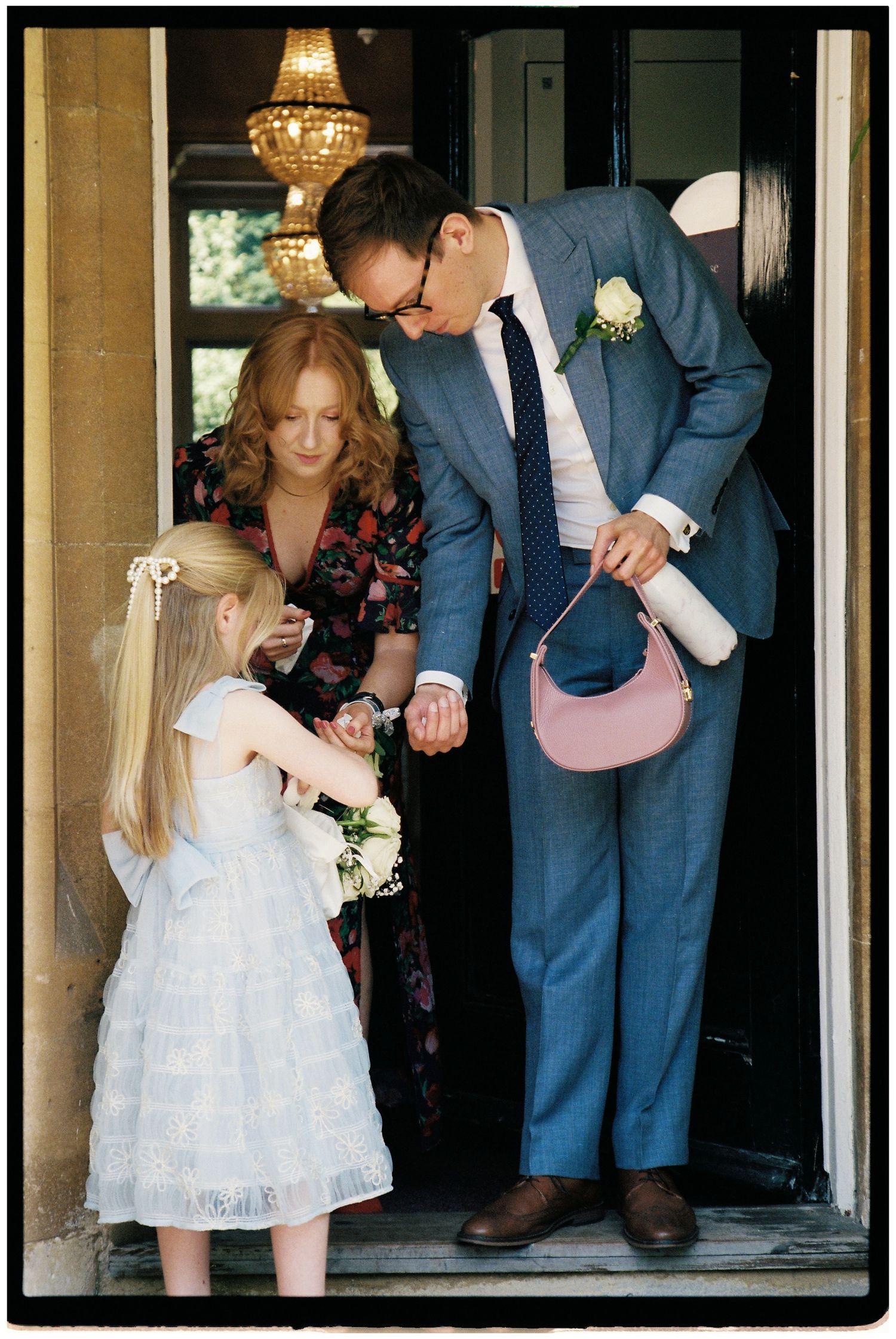 Flower girl handing out confetti to guests on 35mm film.
