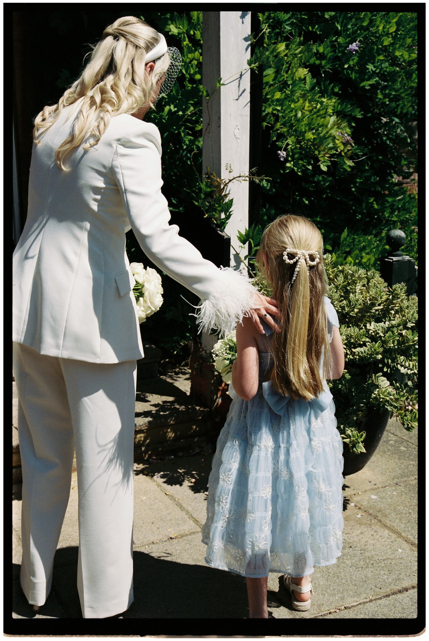 Flower girl handing out confetti to guests on 35mm film.