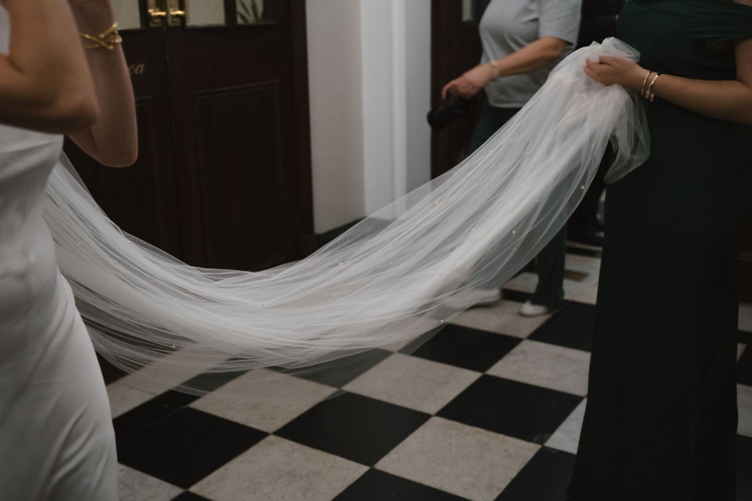 Sister of the bride holding her veil