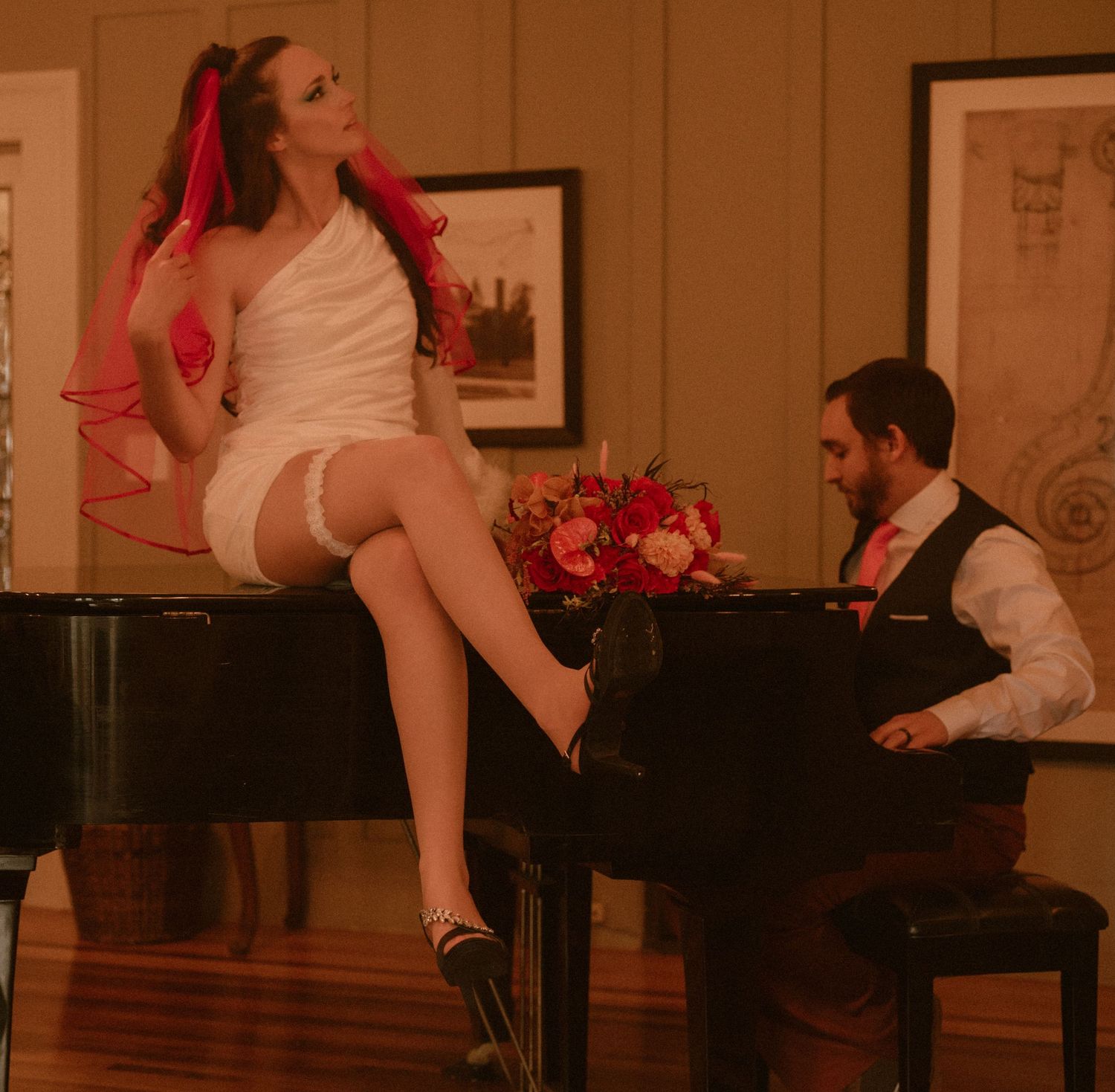 Vintage-inspired scene with a white dress and red accents around a grand piano.