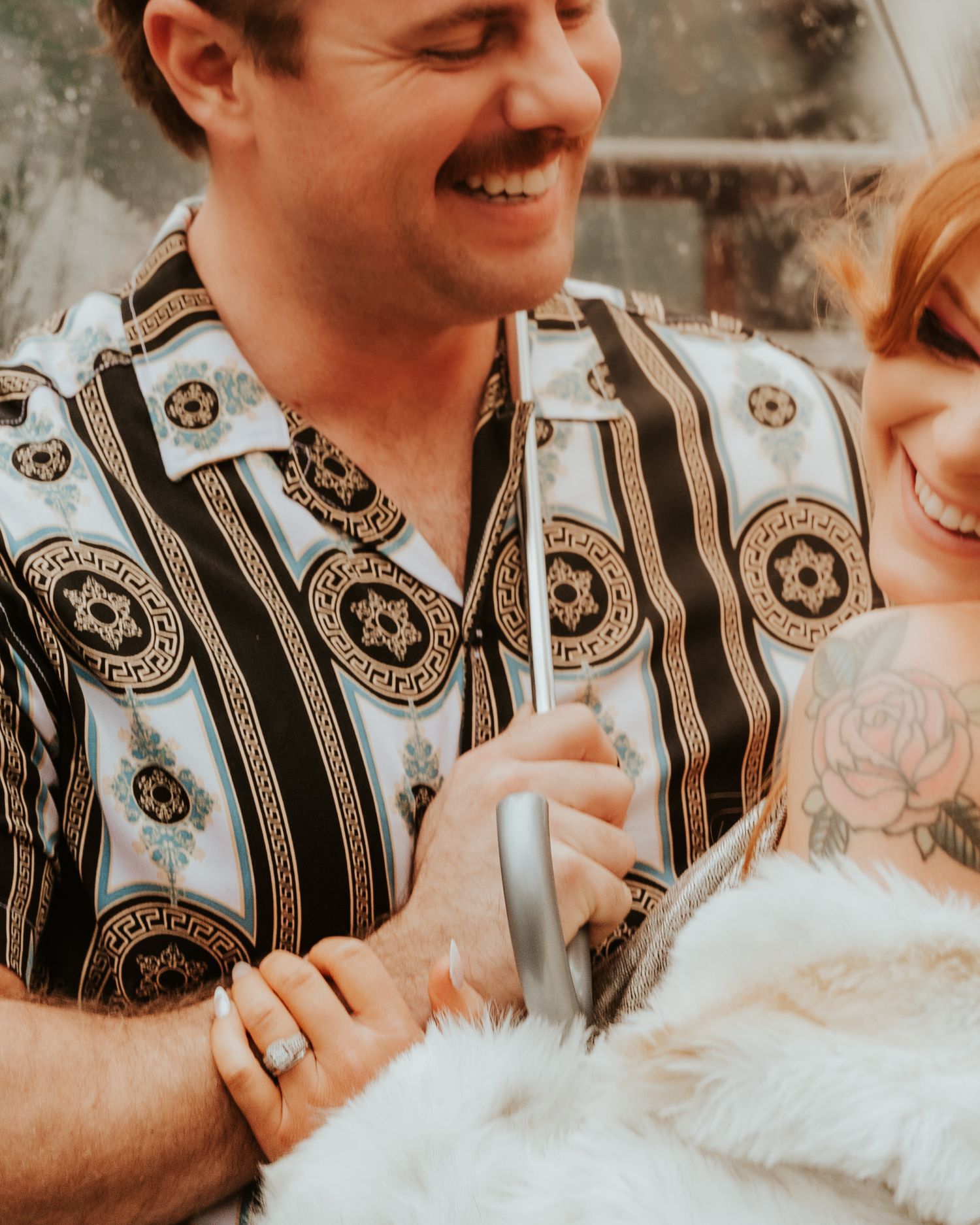 A couple shares an intimate moment wearing matching black and white patterned outfits in a warm-toned setting.
