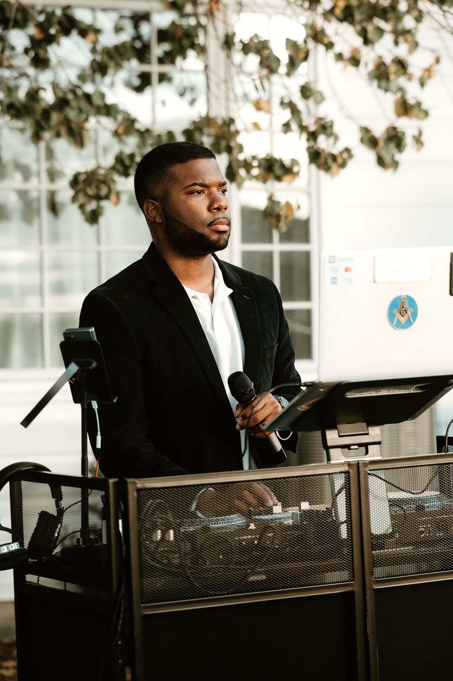 Professional DJ performing at an outdoor event with equipment and laptop setup.