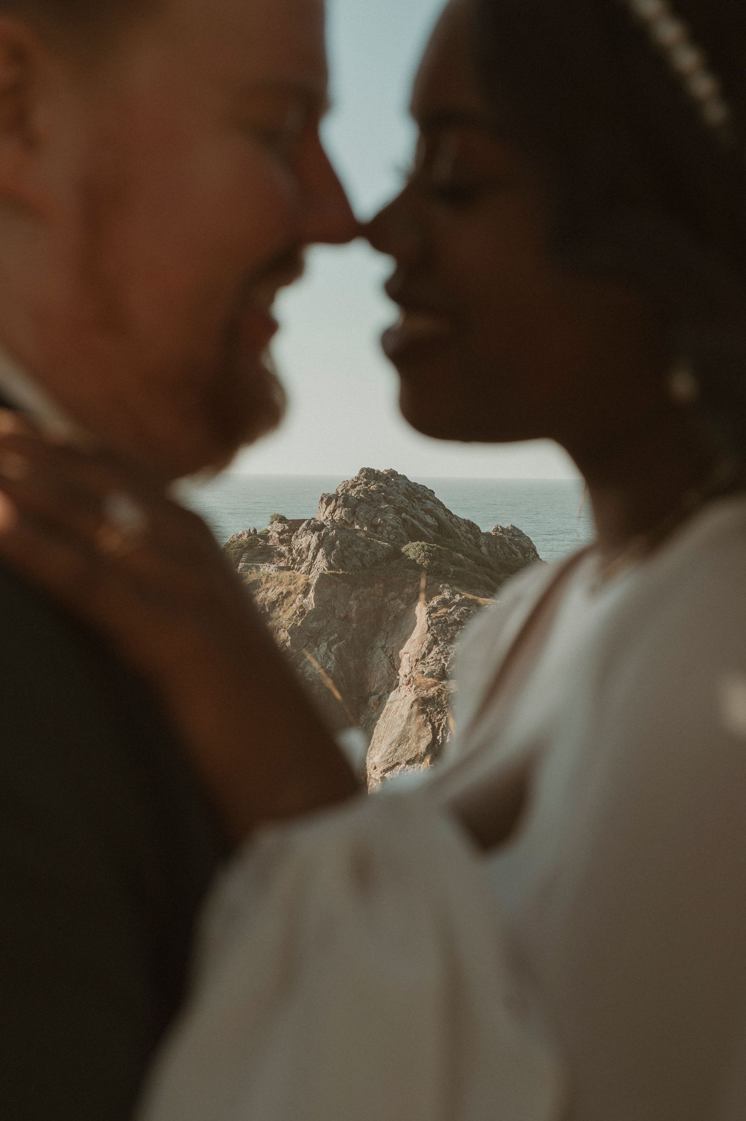 An intimate wedding portrait silhouetted against a majestic mountain backdrop.