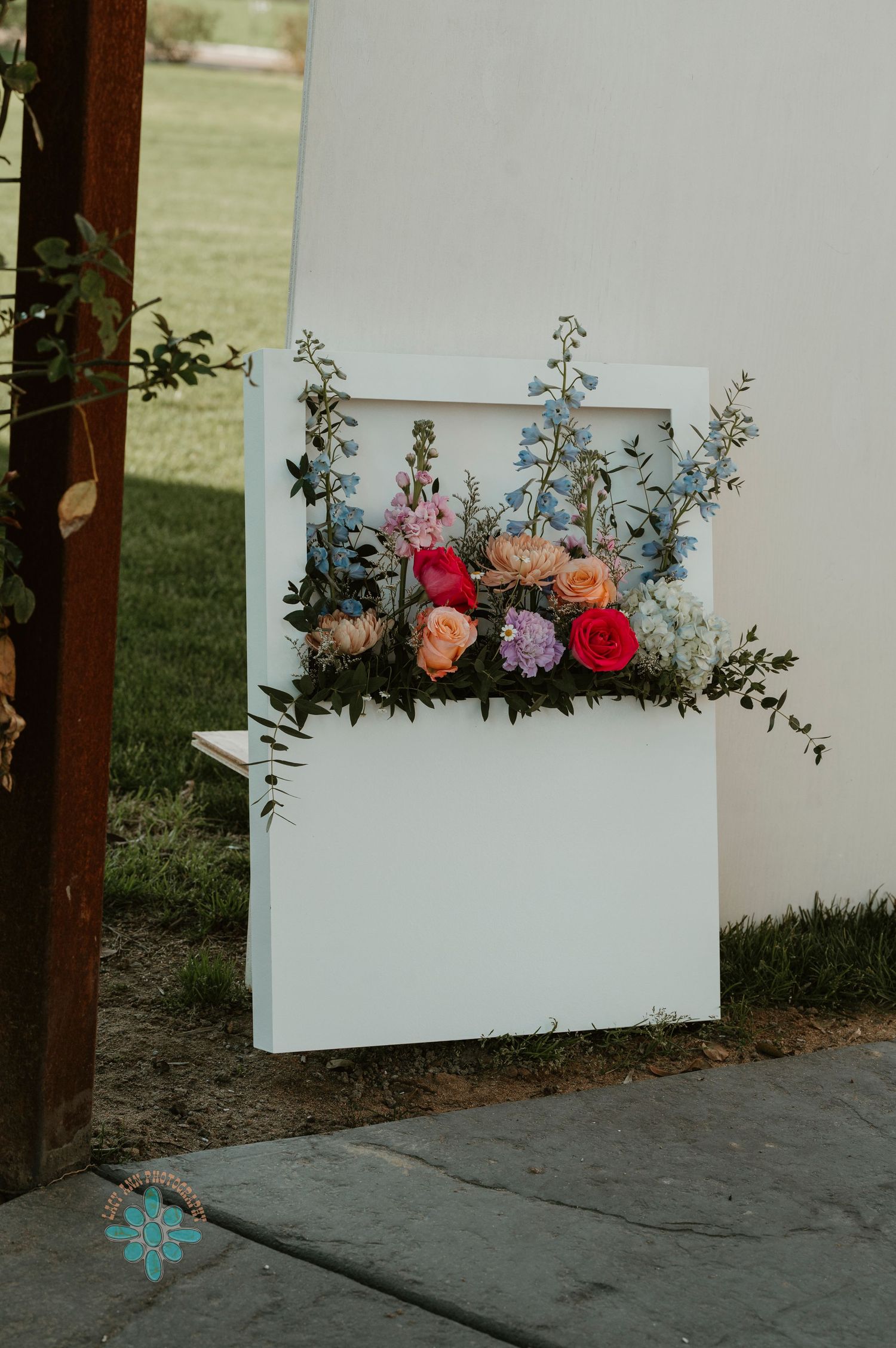 White decorative panel with colorful floral arrangement featuring pink, orange and purple blooms.