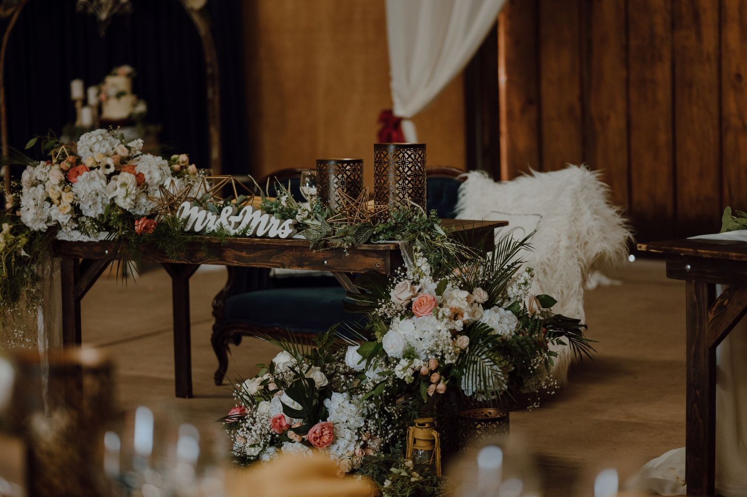 Elegant floral arrangements with white and pink blooms adorning a piano in a rustic indoor venue.
