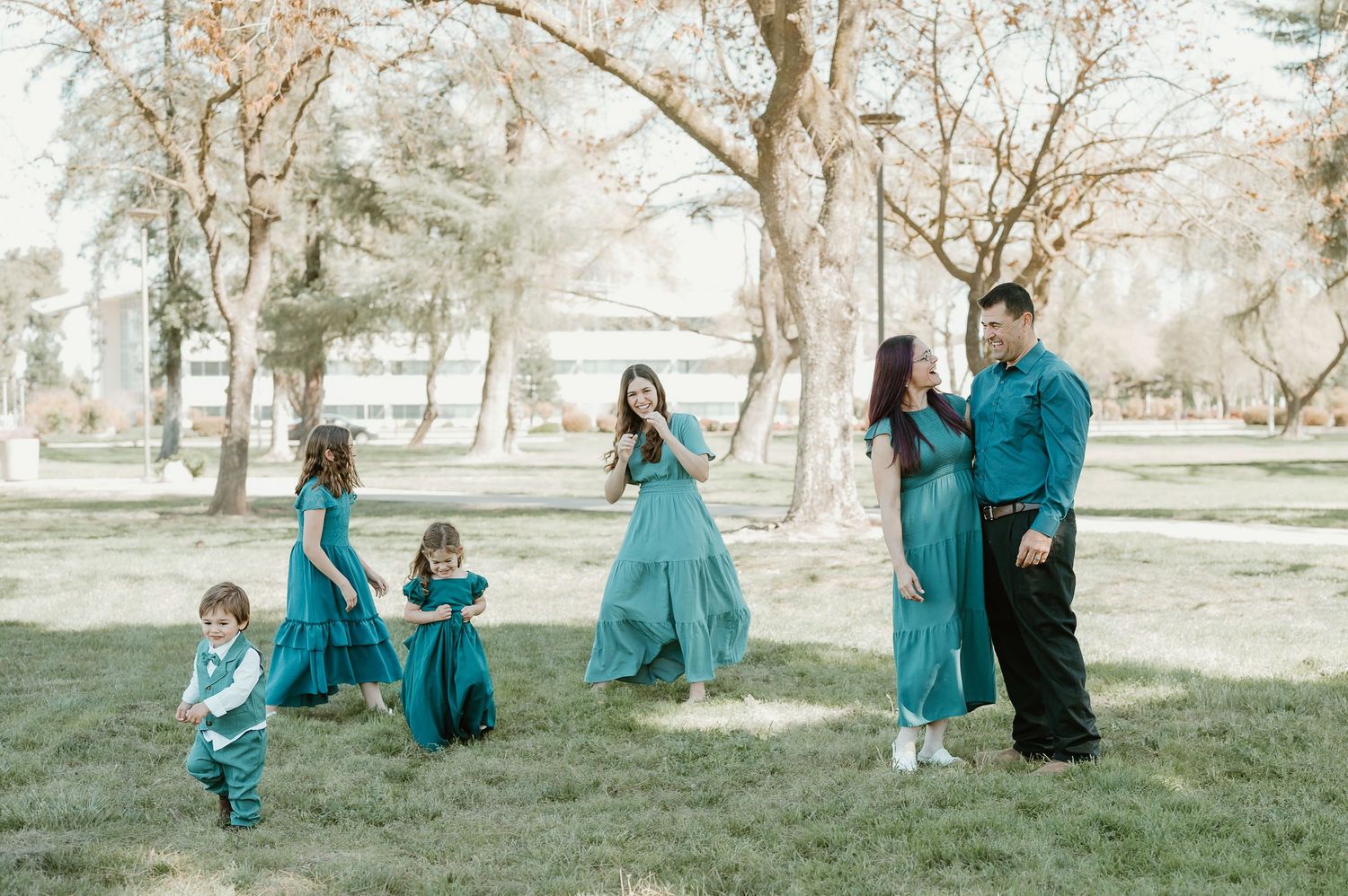 A series of candid family photos in a park setting with people wearing coordinating turquoise outfits in autumn.