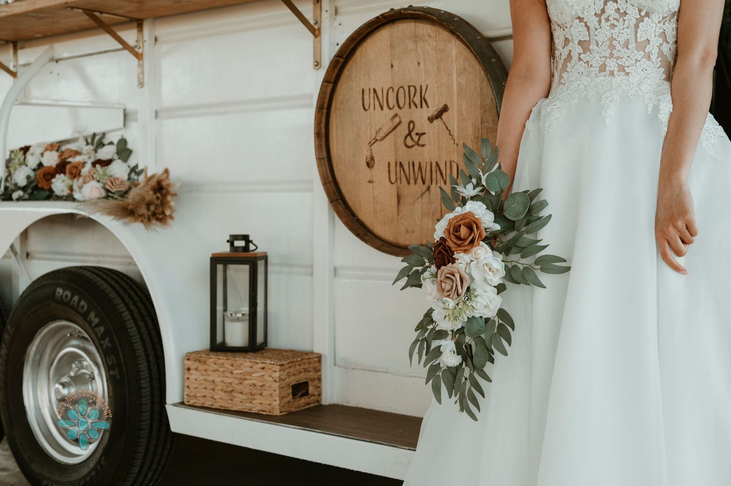 Close-up of wedding bouquet against white mobile bar with rustic wooden barrel detail.