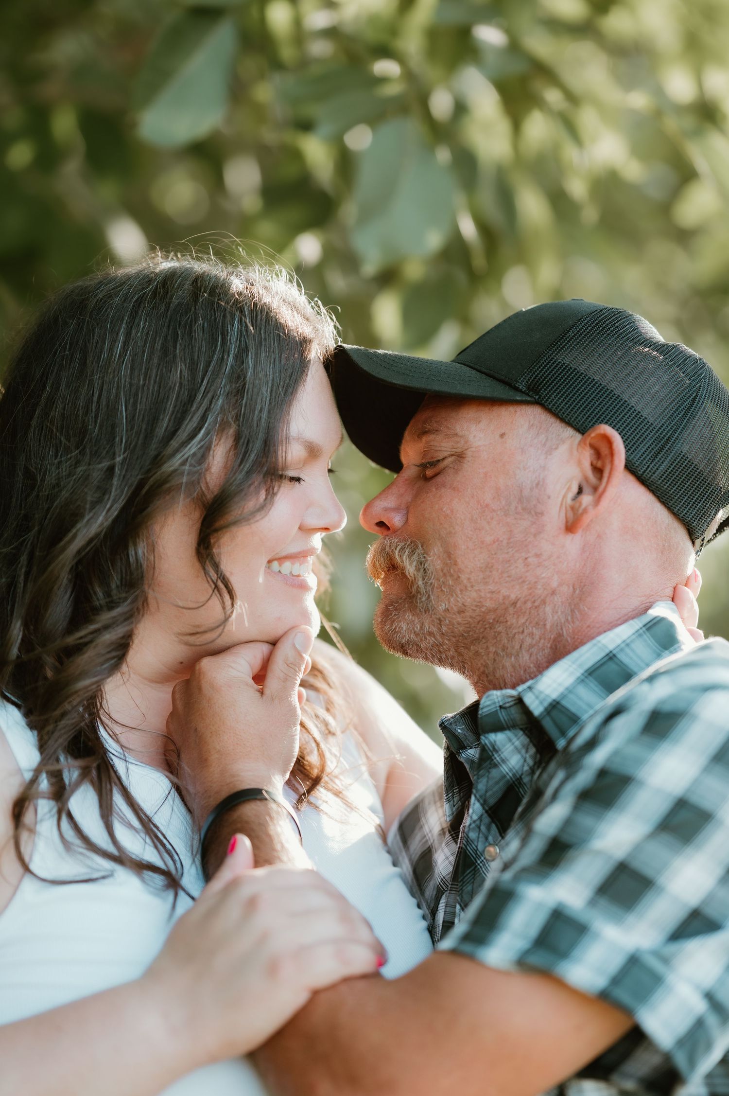 A couple shares tender romantic moments in a series of intimate outdoor portraits with soft natural lighting.