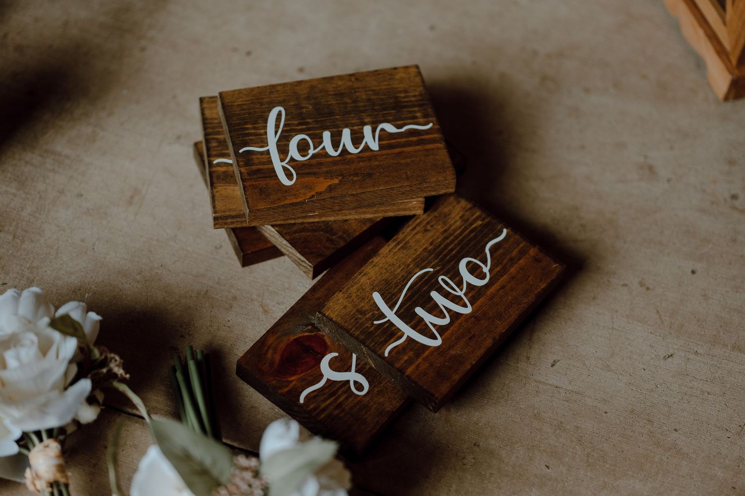 Wooden wedding signs with the words 'love' and 'four' in calligraphy.