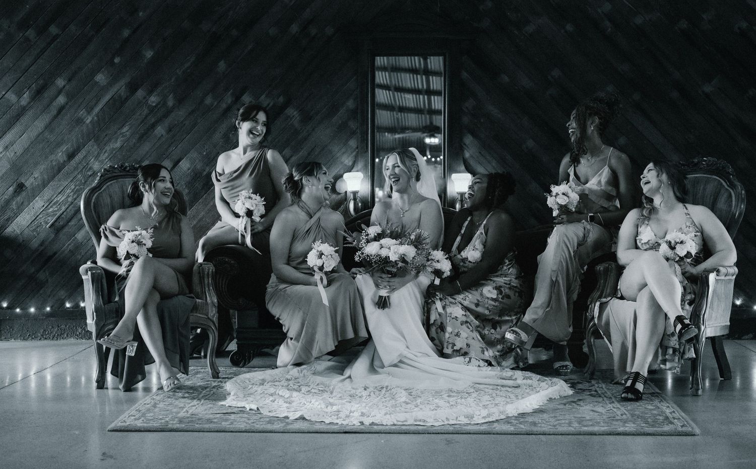 Panoramic view of wedding guests dancing under string lights at an evening reception.