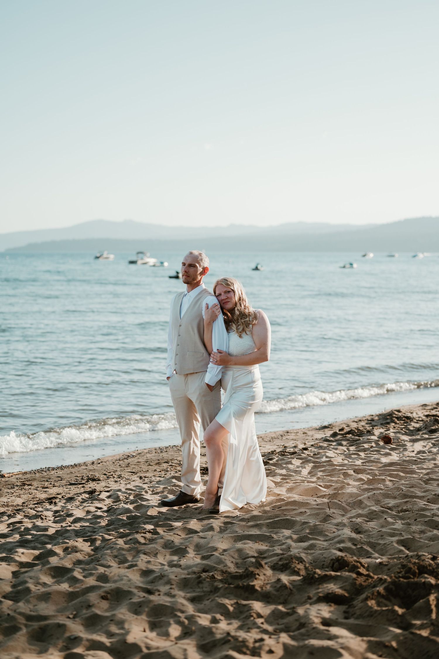 A romantic moment between a couple on a sandy beach at sunset.