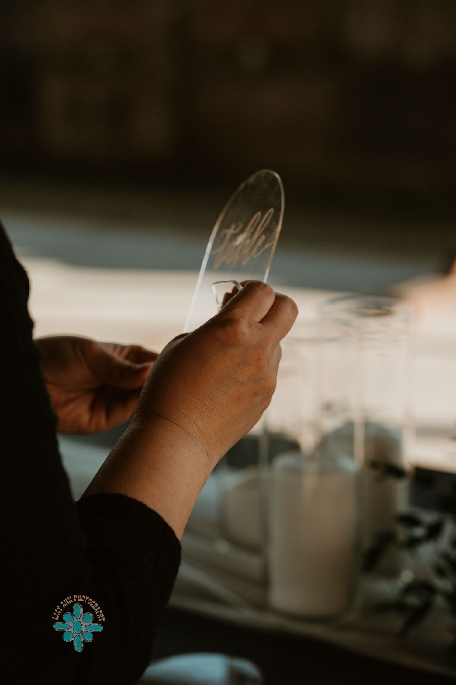 Close-up shot of hands holding a glass measuring tool in a dimly lit kitchen setting.