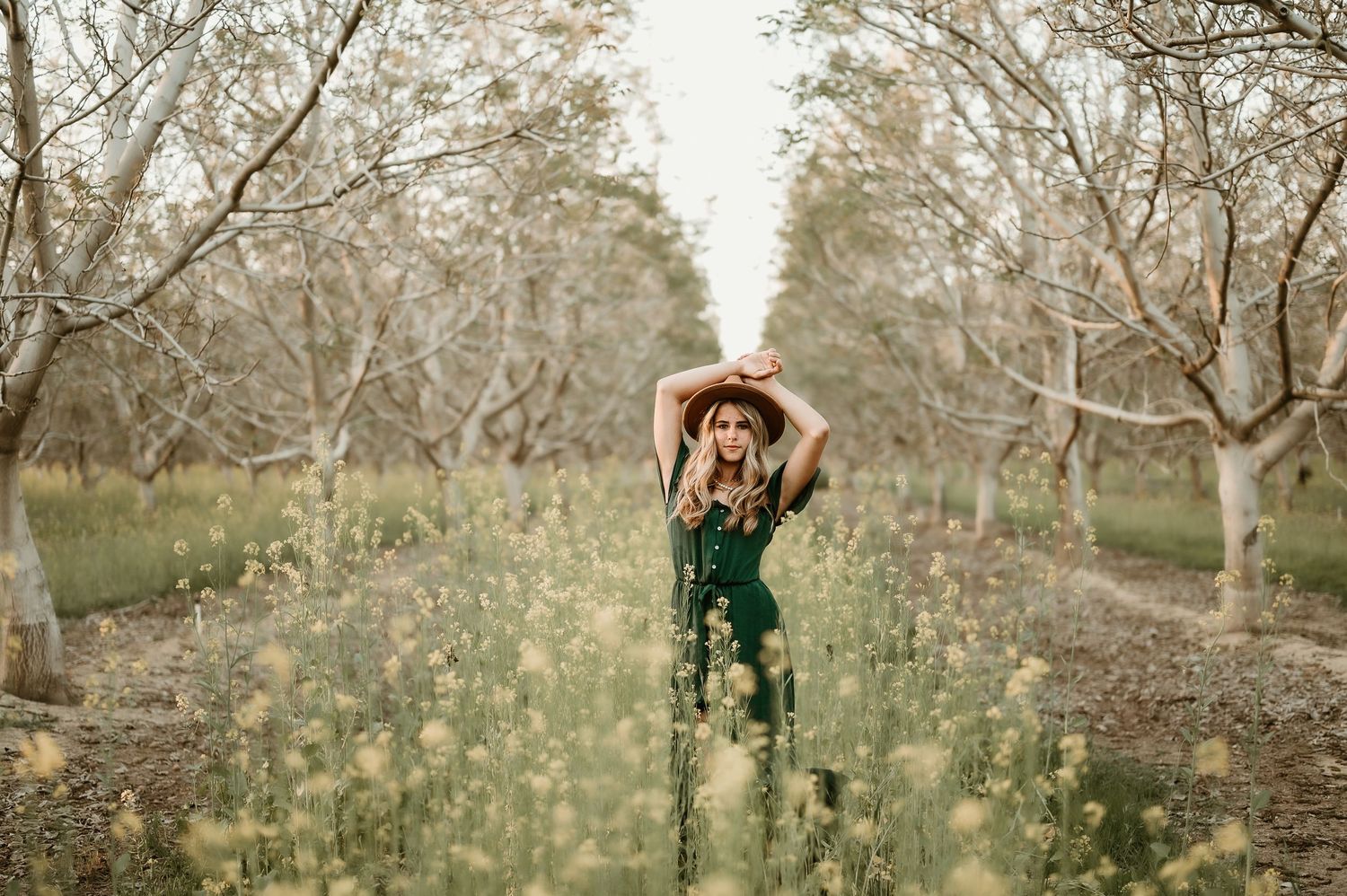 A romantic outdoor photoshoot in an orchard with blooming trees during springtime.