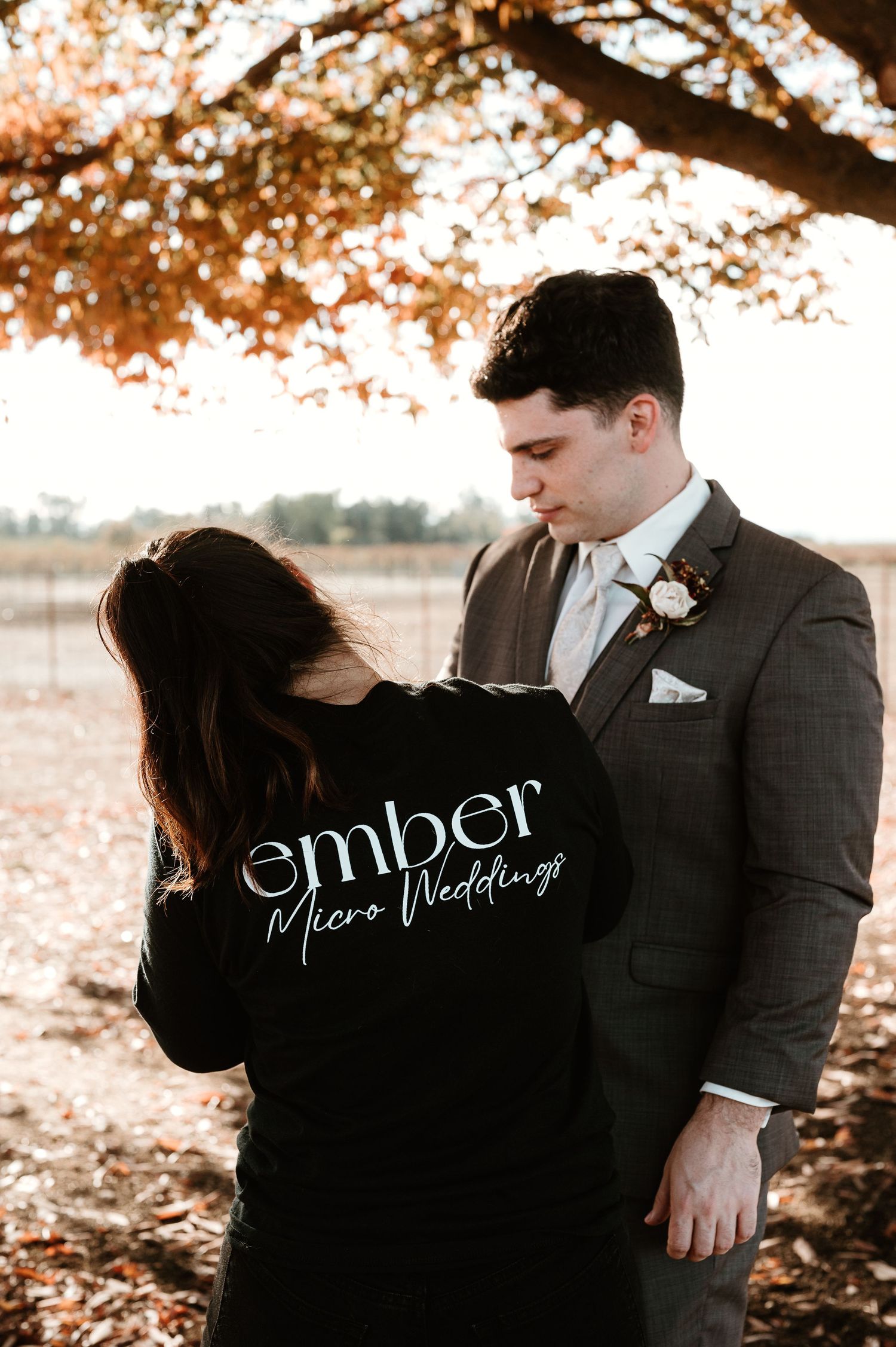 Wedding photography business branding shot featuring ember logo on black jacket.