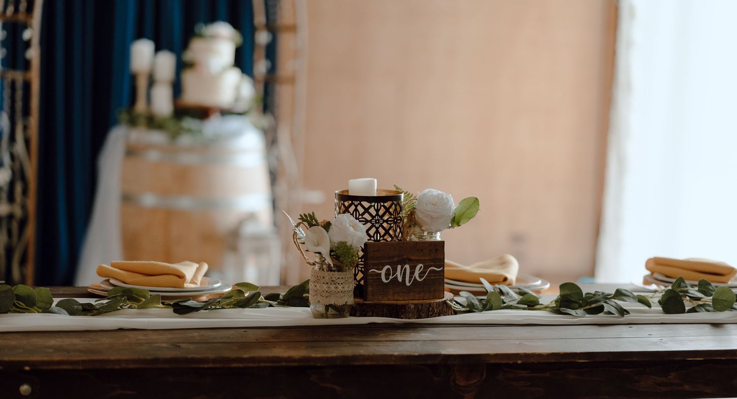 Rustic wedding dessert table setting with vintage decorative elements and white flowers.