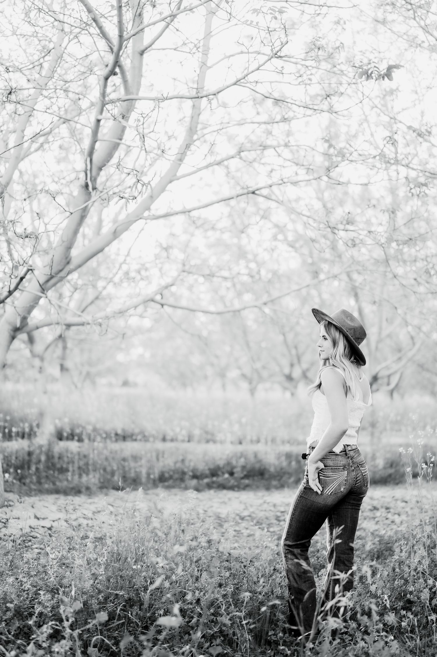 A dreamy black and white portrait in a field with autumn trees creating a peaceful outdoor setting in nature.