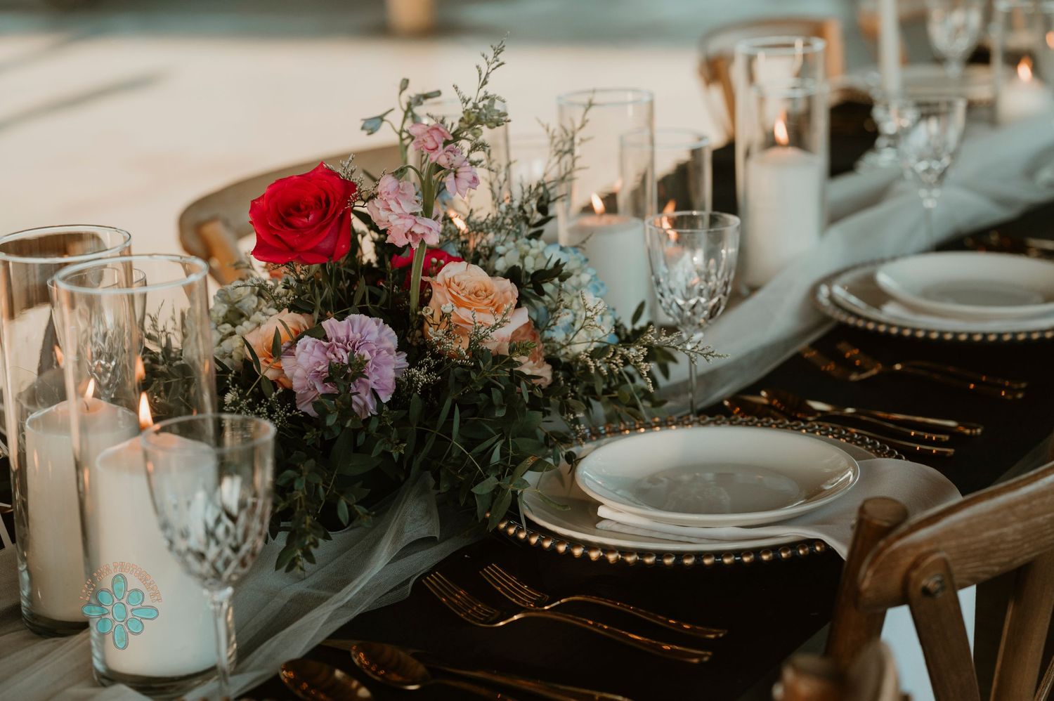 A rustic wedding tablescape with floral centerpieces, candles, and vintage place settings.