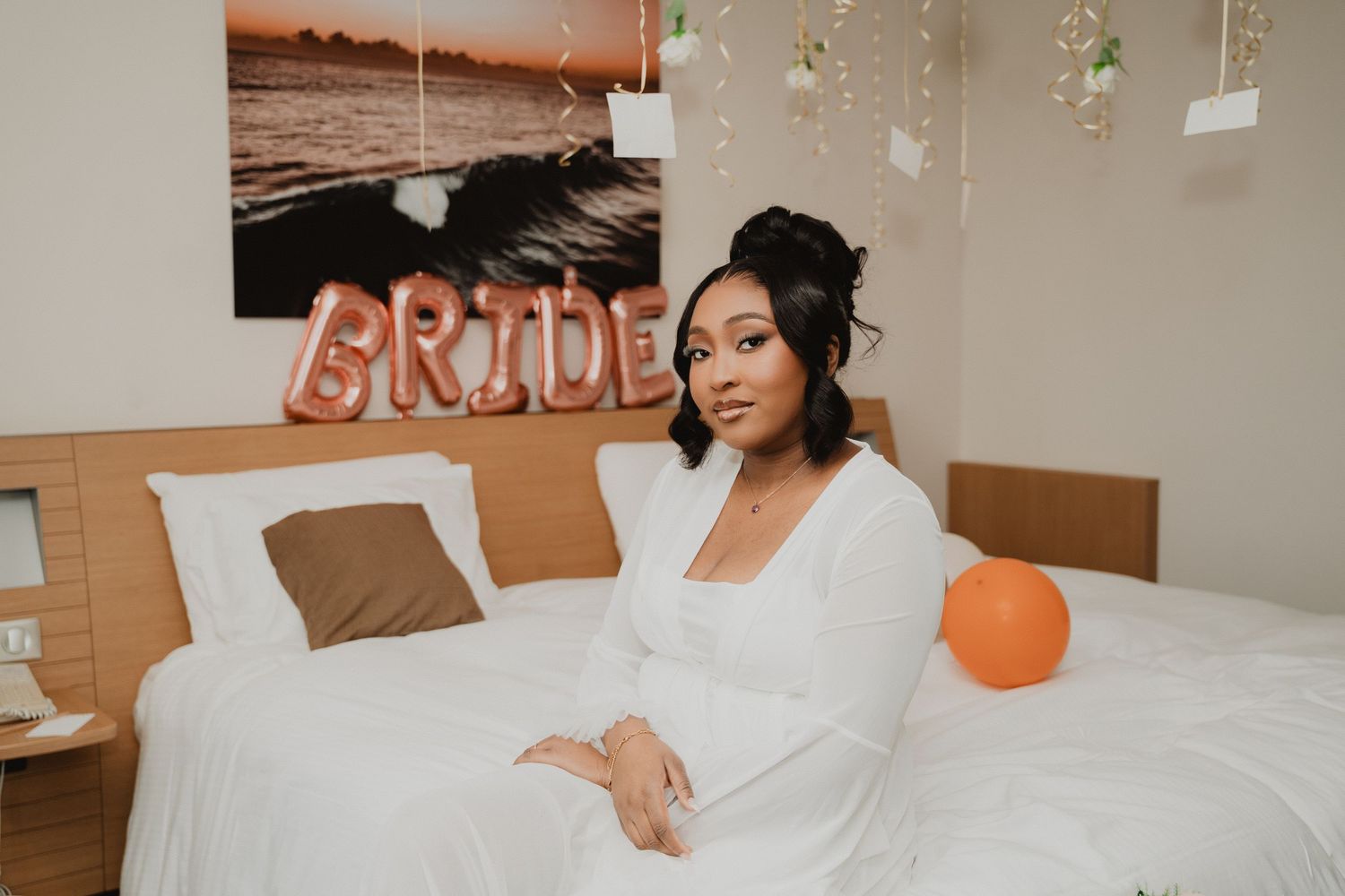 Une chambre décorée de ballons « BRIDE » et d'éléments décoratifs suspendus au-dessus du lit.