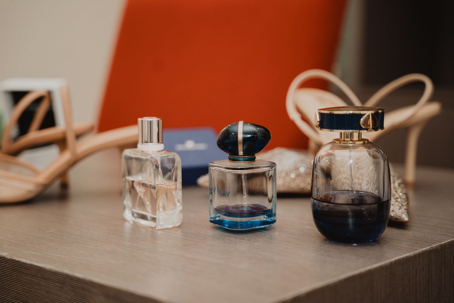Accessoires de mariage et flacons de parfum disposés sur une surface en bois.
