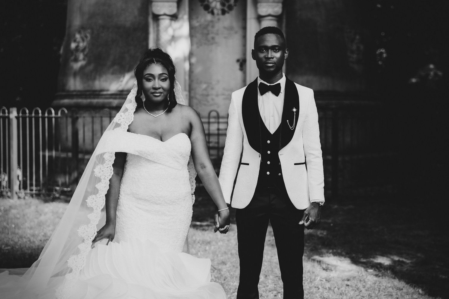 Un couple de mariés élégants partage des moments intimes en tenue de soirée noire et blanche.