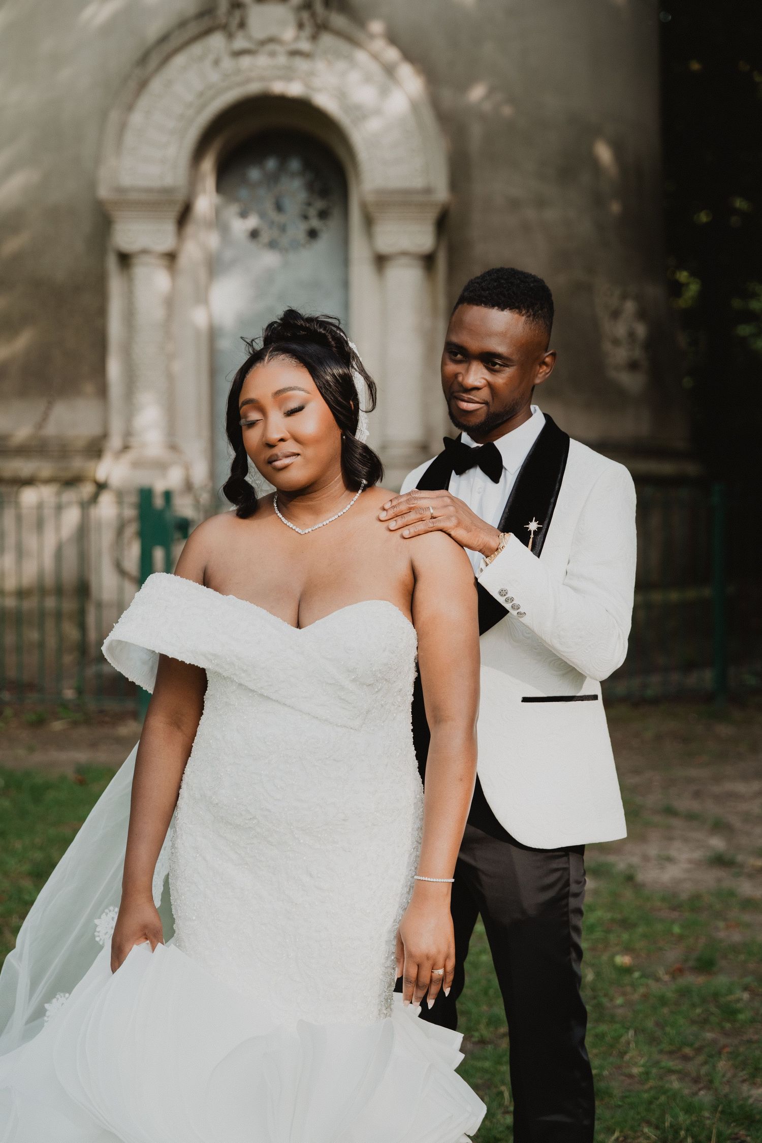An intimate wedding moment captured in front of a decorative stone alcove.