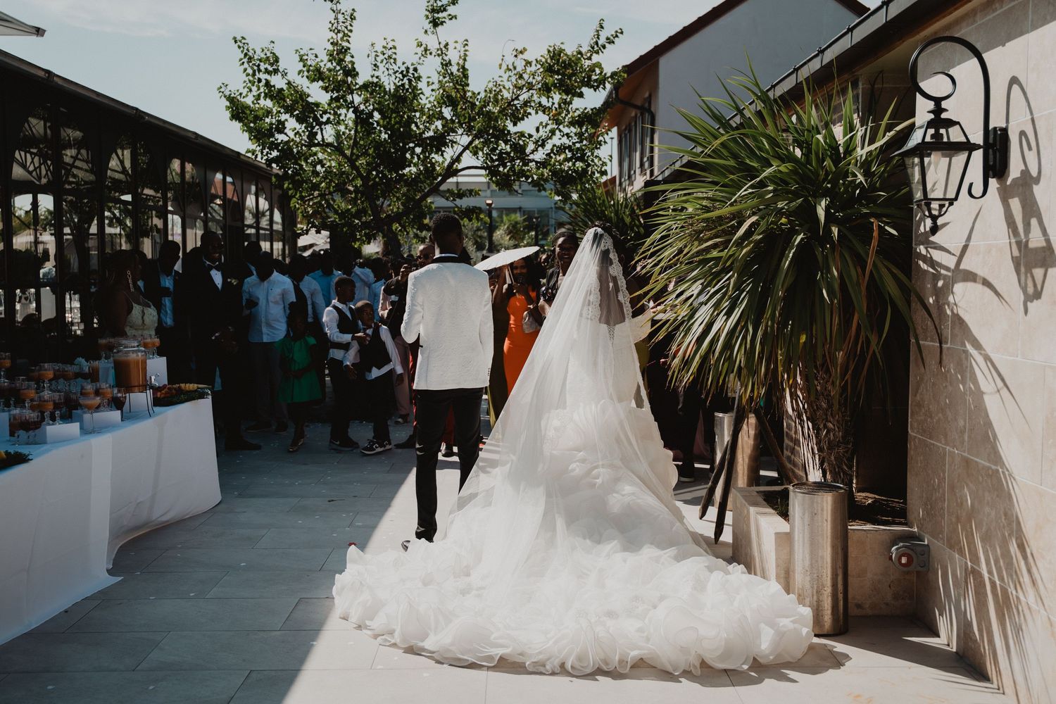 Le cortège nuptial pose en extérieur en tenue de cérémonie, les demoiselles d'honneur portant des robes vert olive.