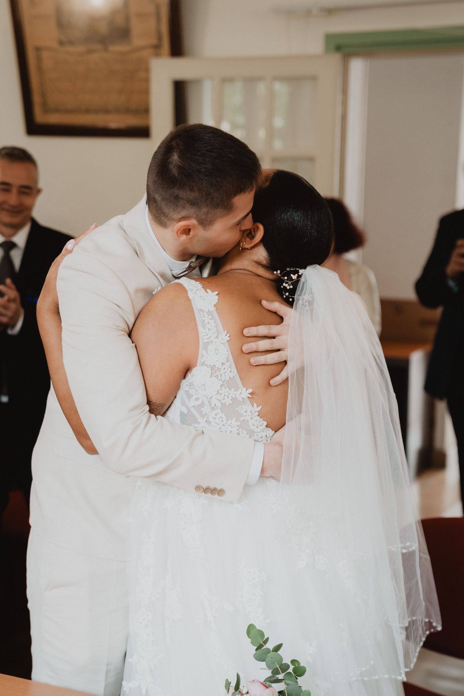 Un tendre moment entre des jeunes mariés échangeant leur premier baiser lors de leur cérémonie de mariage.
